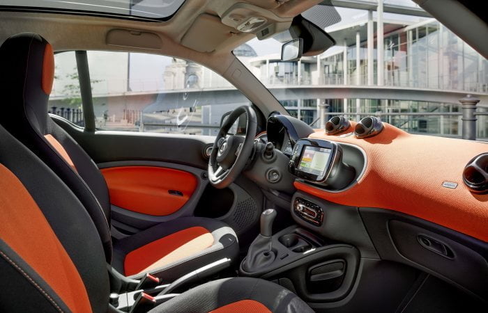 Der neue smart fortwo, 2014 Polsterung in Stoff schwarz/orange, Instrumententafel und Türmittelfelder in Stoff orange und Akzentteile in schwarz/grau, smart Media-System The new smart fortwo, 2014 Upholstery in black / orange fabric, Dashboard and door centre panels in orange fabric and contrast components in black/grey, smart media system
