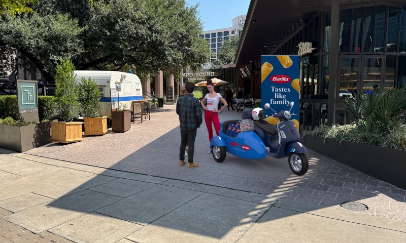 Barillia popup at Austin Fareground with a two people standing near a blue scooter with Barilla signage.
