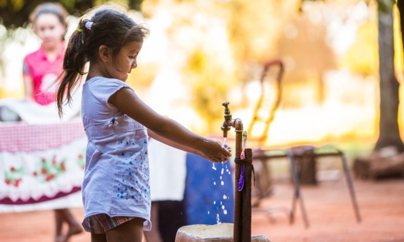 A young person washing their hands with clean water.