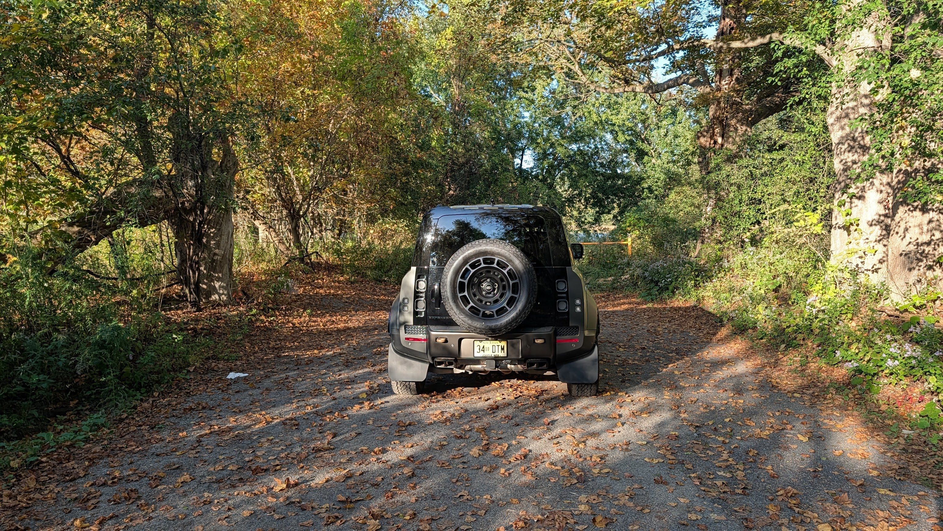 Rear view of a 2025 Land Rover Defender 110 OCTA on a leafy trail